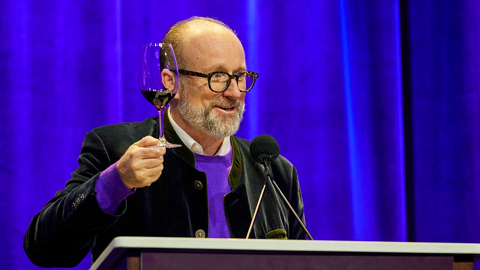 Prince Robert de Luxembourg on stage holding a glass of red wine at the 2024 New York Wine Experience